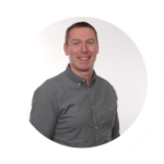 Light-skinned appearing man with short brown hair with a grey shirt 